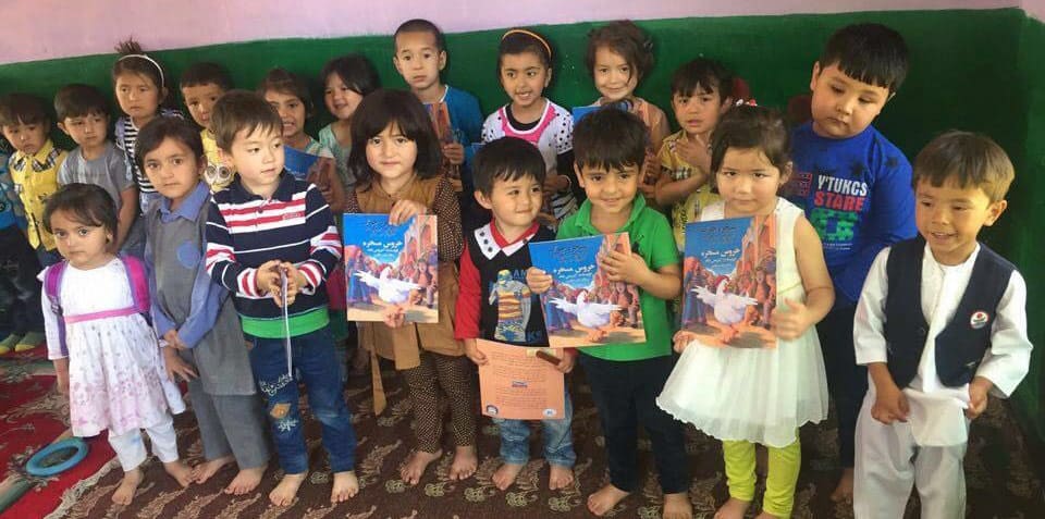 Young Afghan students with Hoopoe books delivered thanks to Moska Mobil Library