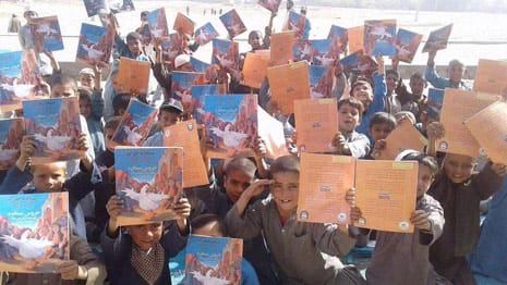 Afghan boys with copies of the book The Silly Chicken