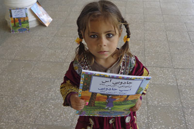 Afghan girl with the book The Magic Horse