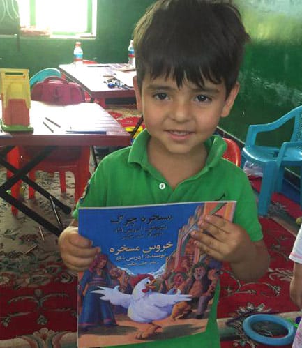 Young Afghan boy pleased to have a copy of The Silly Chicken from Moska Mobil Library
