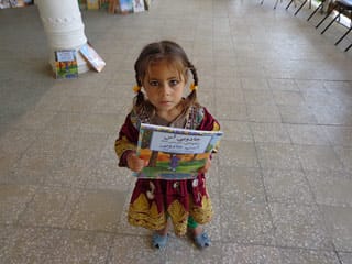 Little girl with Hoopoe books at International Literacy Day event in Afghanistan