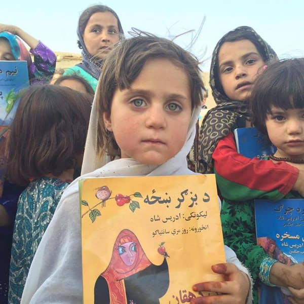 Young Afghan girl holding the book The Farmer's Wife from Hoopoe Books