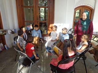 group of kids in a circle with Hoopoe books at International Literacy Day event in Afghanistan