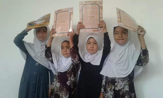 4 Afghan girls with copies of The Woman and the Eagle