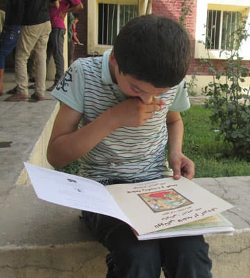 a young man from an orphanage in Kabul enjoy books of their own which were kindly distributed to them by the Afghan Mobile Mini Circus for Children (MMCC)