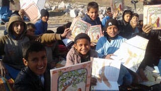 Boys in Afghanistan with copies of the book The Old Woman and the Eagle