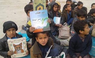 Afghan kids outdoors with Hoopoe books from Moska Mobile Library