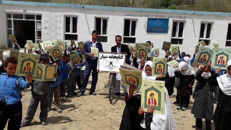 Saber Husseini delivering Hoopoe Books to Afghan children in front of school