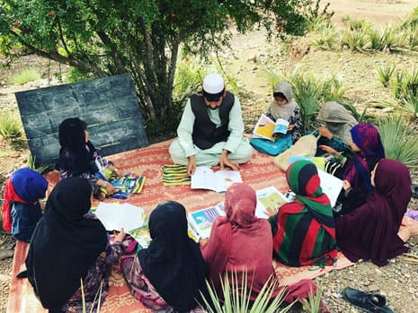 Afghan girls in an outdoor reading circle with The Clever Boy and the Terrible, Dangerous Animal