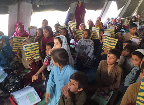 Boys and girls in a tent school with Hoopoe books