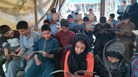 Kids reading Hoopoe books in a tent 