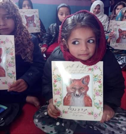 Afghan girl with a Hoopoe book distributed by Care