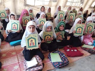 Afghan girls in a tent classroom with Hoopoe books