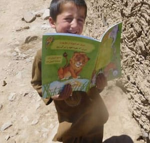 Afghanistan Child reading book- distributed by Hoopoe Books