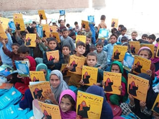 Afghan kids outside with Hoopoe books