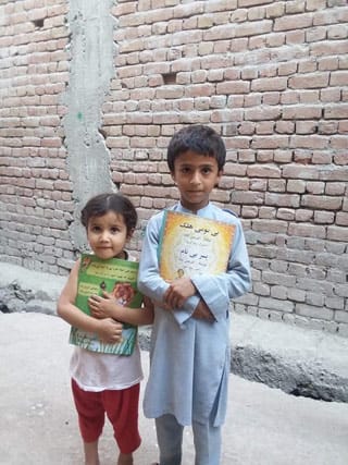 2 small children in Afghanistan holding Hoopoe books