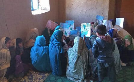 Afghan kids holding up Hoopoe books